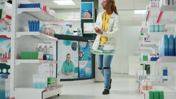 Afrikansk Amerikansk Kvinna Tar Piller Och Vitaminer Från Hyllor Tittar — Stockvideo