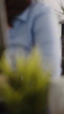 Vertical video: Business woman finding creative solutions at desk, writing online data on files planning new investment. Young adult checking online analytics on documents, management project.