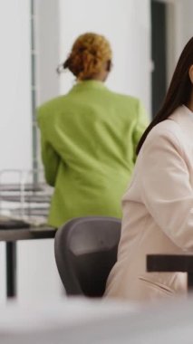 Vertical video: Business woman working with analytics and statistics, analyzing online data on papers and computer. Executive assistant planning new research for investment, company growth. Handheld