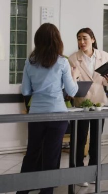 Dikey video: Çeşitli çalışan grupları şirket ofislerinde büyüyen fikirler üzerinde beyin fırtınası yapıyor, kalkınma için iş çözümleri buluyor. Toplantı brifinginde proje işbirliği yapan insanlardan oluşan bir ekip.