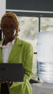 Vertical video: Startup worker analyzing annual data report on laptop, checking analytics before planning new business investment in office. Young adult analyzing online statistics, profit growth.