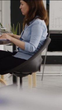 Vertical video: Business woman checking investment plan on computer, looking at annual data report for creative solution to increase profit. Young employee planning development with analytics