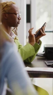 Dikey video: İş molasında cep telefonu kullanan kadın çalışan, sosyal medya uygulamasında geziniyor. Yönetici asistanı akıllı telefondan online tarayıcıya bakıyor, yeni bir strateji planlıyor. El kamerasıyla..