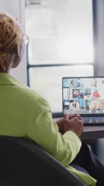 Vertical video: Executive assistant talking on remote video call at desk, meeting with business people online on videoconference chat. Team of coworkers planning growth on internet teleconference