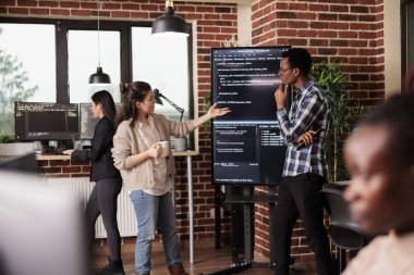 Diverse software developers working on it project for the company network technology, utilizing their expertise in coding systems. Tech enginners javascript code in programming agency office.