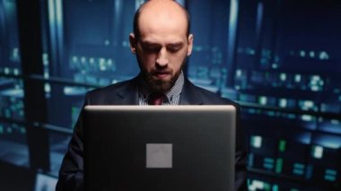 Sistem yöneticisi modern sunucu odasında dizüstü bilgisayarları kontrol ediyor. Veri merkezi teknisyeni ağ endüstrisi için yedekleme dijitalleştirmesini analiz ediyor. El kamerasıyla..