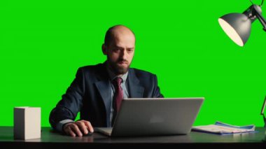 Office employee answering phone call on green screen, posing over isolated chroma key template in office. Young manager using smartphone on blank copyspace mockup backdrop at desk.