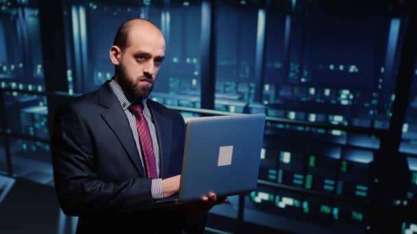 Инженер Сервера Осматривает Работающий Процессор Ноутбуком Стоящий Профессиональном Дата Центре — стоковое видео