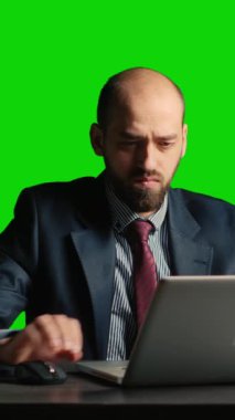 Vertical video: Caucasian employee dealing with neck and back pain, posing over greenscreen backdrop. Young adult in suit being unhappy and frustrated, work under pressure on chroma key isolated