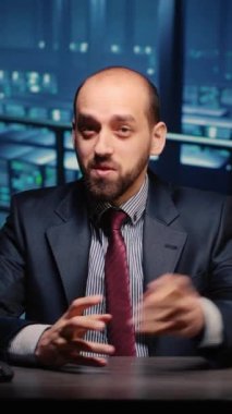 Vertical video: POV of system engineer talking on online videocall in data center server room, young adult working in artificial intelligence render farm. IT specialist using remote videoconference