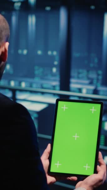 Pionowe Wideo Inżynier Sieci Sprawdza System Zielonym Ekranie Używając Tabletu — Wideo stockowe
