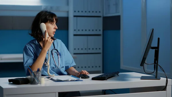 Physician Nurse Answering Landline Phone Discussing Patient Report Remote Doctor — Stock Photo, Image