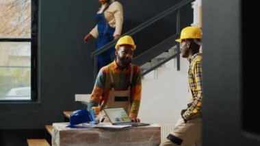 Cheerful workers laughing and having fun in storehouse, preparing merchandise boxes for shipment. Team of employees doing quality control for supplies and cargo in carton packages.