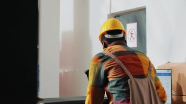 African american men bumping fists before finishing work, organizing manufacturing products in storage room. Depot employees doing fistbump after checking merchandise packages.