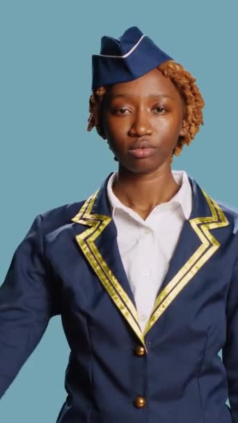 垂直ビデオ アフリカ系アメリカ人の少女がカメラで軍の敬礼を行い スタジオで軍隊に感謝を示しています 若いです航空ホステスでプロの職業は 制服を着て 幸せであることと — ストック動画