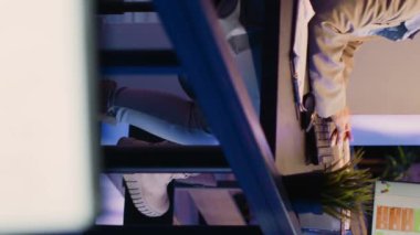 Vertical video: Executive manager feeling frustrated working at night, checking business charts to plan financial graphs report for startup growth. Young adult working under pressure to plan