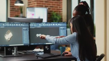 Female engineers analyzing clamp component prototype, working with industrial 3d software. Team of mechanical developers creating engine product for machinery production, creative asset.