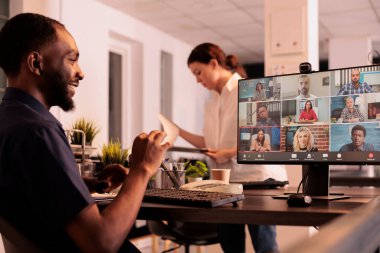 African american office worker having corporate videocall, discussing business plan with remote team on teleconference. Employee talking with colleagues on online meeting, attending videoconference