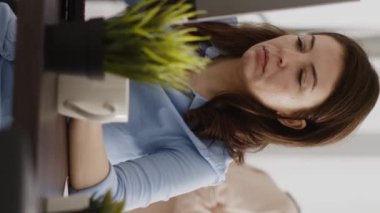 Vertical video: Agency employee working in corporate office with pc, analyzing online data statistics on computer screen. Young entrepreneur looking at company results and analytics. Handheld shot.