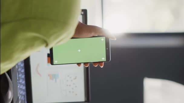 垂直视频 女经理看着办公室的绿色显示屏 在手机上使用孤立的模拟模板 在协同工作空间中使用空白复制空间模型的年轻员工 — 图库视频影像