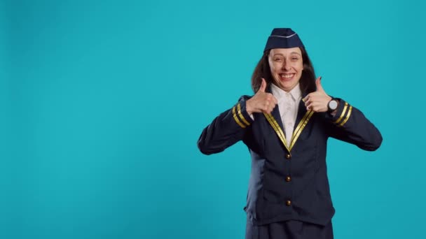 年轻的空姐在演播室里举起大拇指 表现得很好 并表示赞同 穿着航空制服微笑的空姐表示赞同和成功 在相机上做得很好 — 图库视频影像