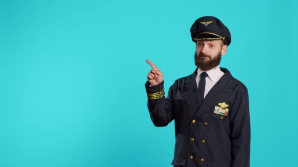 空勤人员机长指向演播室的左右两侧 指示方向侧向 并在商业航班上工作 男模装扮成专业飞机驾驶员 — 图库视频影像