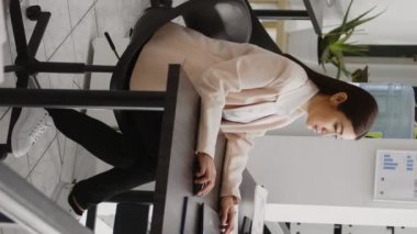 Vertical video: Startup manager reading online analytics and statistics to plan new business strategy, analyzing marketing report to create agency growth. Female employee planning investment for