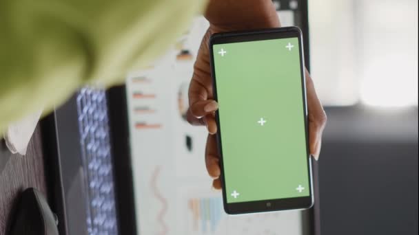 垂直视频 妇女在代理办公室看带有绿色屏幕的水平显示 在智能手机上用空白的模拟模板工作 同事空间中使用隔离色键的青年工人 — 图库视频影像