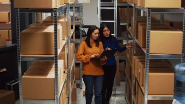 Team of women doing stock logistics with computer, checking merchandise for distribution management. Business partners looking at logistics data on laptop, financial planning.