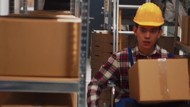 倉庫内の車椅子の移動箱の若い大人は 収納室の棚から製品をチェックします 障害のある男性従業員は ビジネス開発のための注文で働いています 手持ち撮影 — ストック動画