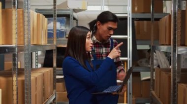Owner and employee analyzing stock logistics on pc, doing quality control for order management and supply chain. Asian people using laptop to do inventory in storage room, business plan.