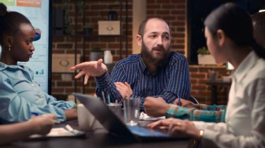 İş toplantısı, pazarlama stratejisini açıklayan adam, şirket sunumunu tartışan iş arkadaşları. Yönetim kurulunda çalışan iletişimi, çeşitli ofis çalışanlarının takım çalışması.