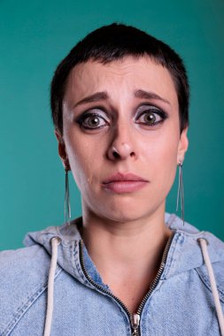 Portrait of young adult standing over isolated background having sadness and depressed expression, crying after hearing the news. Displeased woman having mentak breakout in front of camera