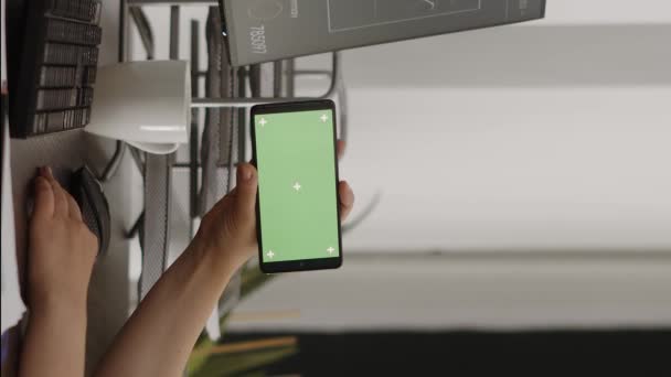 垂直视频 女经理看着手机上的水平绿色屏幕 在公司办公室工作 用彩色键显示 年轻女人用孤立的模型分析智能手机屏幕 — 图库视频影像