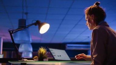 Corporate employee analyzing financial report with diagrams and graphs, planning business investment. Young woman working on development with marketing analytics. Handheld shot.