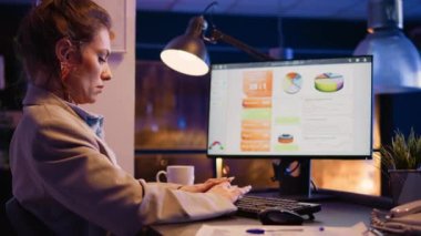 Startup entrepreneur typing data on analytics report and planning financial investment, working on business development. Female employee analyzing diagrams statistics at desk. Handheld shot.