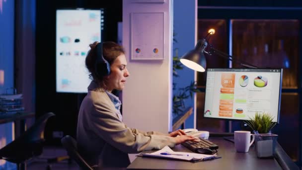 Mulher Negócios Trabalhando Noite Ouvindo Música Escritório Corporativo Usando Diagramas — Vídeo de Stock