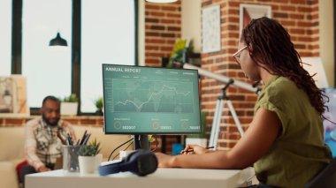 Veri diyagramlarındaki mali raporları analiz eden kadın çalışan, satış bilgilerini bulmak için internet istatistiklerini kullanıyor. Mali pazarlama sonucu için evden çalışan bir kadın. El kamerasıyla..