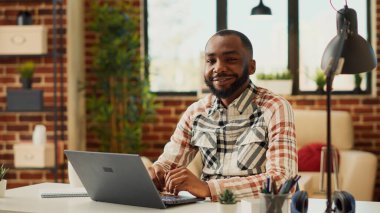 Ofis çalışanı masada oturup dizüstü bilgisayar kullanıyor, şirket ağ verileriyle muhasebe yapmayı öğreniyor. Uzaktan çalışan ve şirket satış bilgilerini kontrol eden serbest çalışan bir erkek..