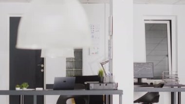Empty coworking space in business corporation, digital agency workplace with multiple computers in open space. Corporate department center with boardroom and startup workstations.