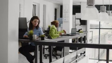 Female entrepreneur checking annual report on screen, planning business investment for company development. Startup employee checking data analytics on laptop, taking notes on files.