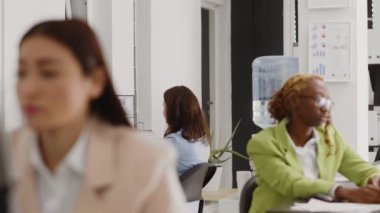 Office worker talking to coworkers on video call, attending corporate meeting with videoconference on computer. Female employee having telework discussion on webcam, business agency.