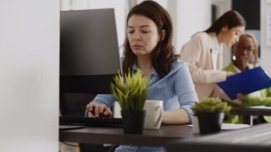 Şirket ofisinde bilgisayar ekranında online veri istatistiklerini analiz ederek çalışan bir çalışan. Şirket sonuçlarına ve analizlerine bakan genç girişimci. El kamerasıyla..