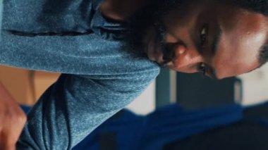 Vertical video: Male business owner analyzing supply chain and logistics to work on retail selling, using stock management for startup development. Office worker looking at shelving products. Handheld