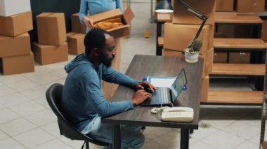 Team of startup partners doing quality control on products from storage room, checking cardboard packages of stock. Young entrepreneurs preparing goods in boxes, distribution orders.