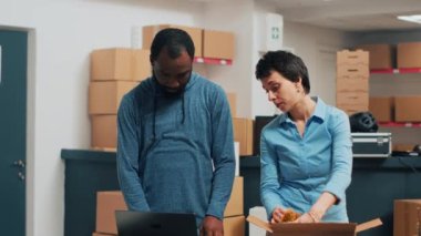 Two entrepreneurs checking supply chain on storehouse shelves, planning shipment and storage management. Young people working on business development and logistics, stock distribution.