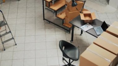Empty warehouse with stacks of cardboard packages, small business concept with shelves and racks of merchandise. Product packed in boxes used for shipment and delivery, storage room.