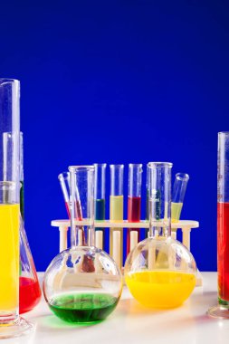 Renkli sıvı ile bir tablo üzerinde mavi arka plan kimya laboratuar. Biyoloji donatımı