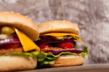 Delicious home made snack burgers on wooden plate. Fast food. Unhealthy snack