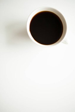 Over top view of coffee cup on white surface